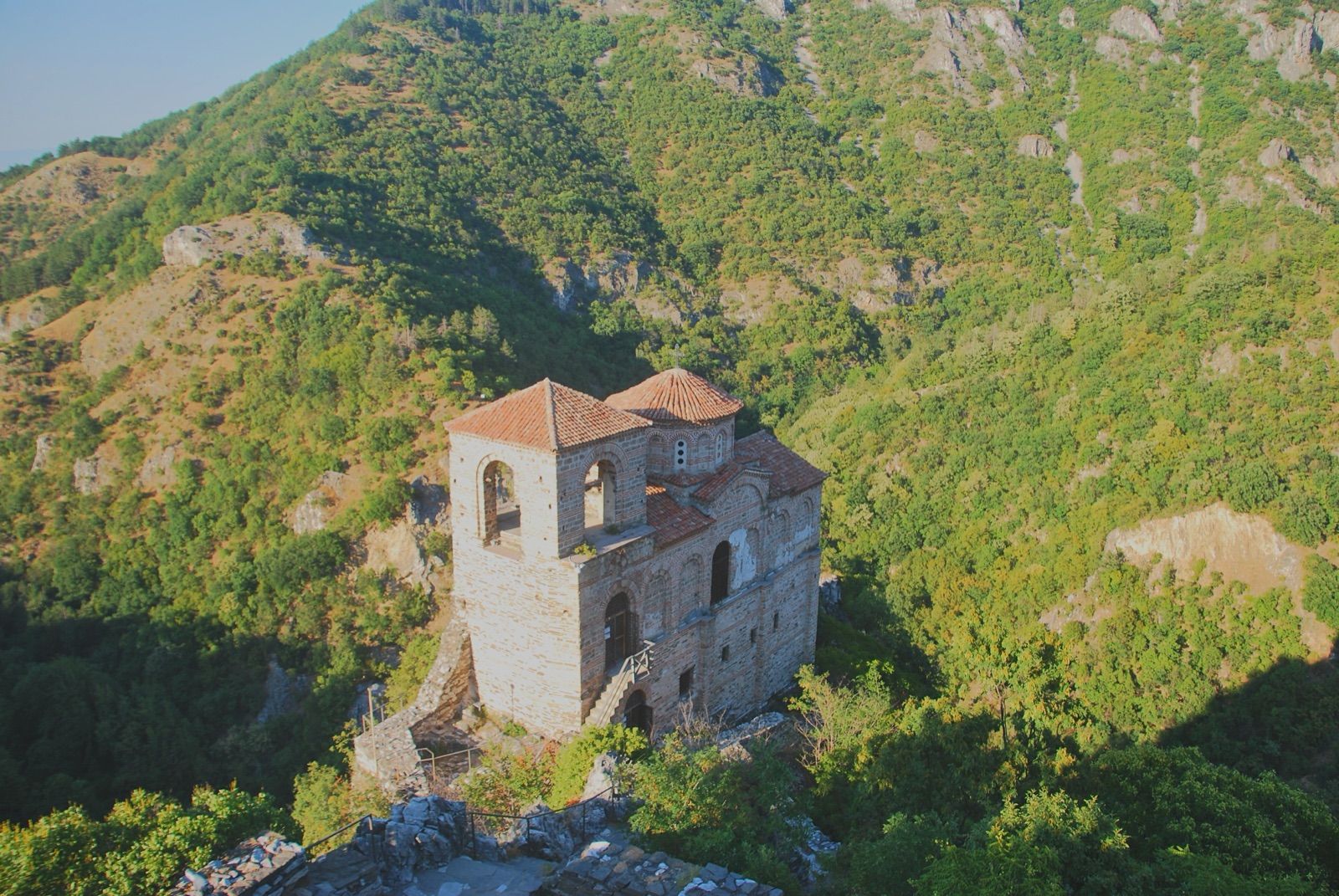 Iglesia medieval de la fortaleza de Asen sobre un risco, rodeada del paisaje montañoso de los Ródopes