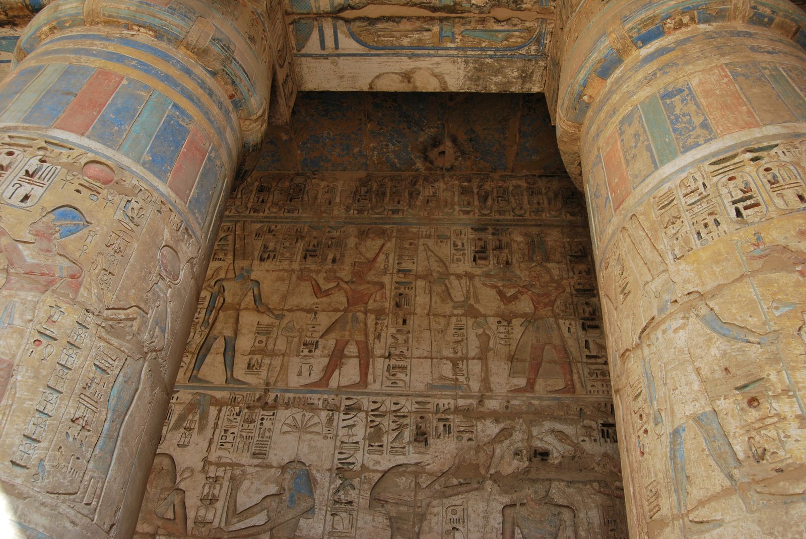 Columnas de un templo egipcio con relieves y restos de policromía original en azules y ocres