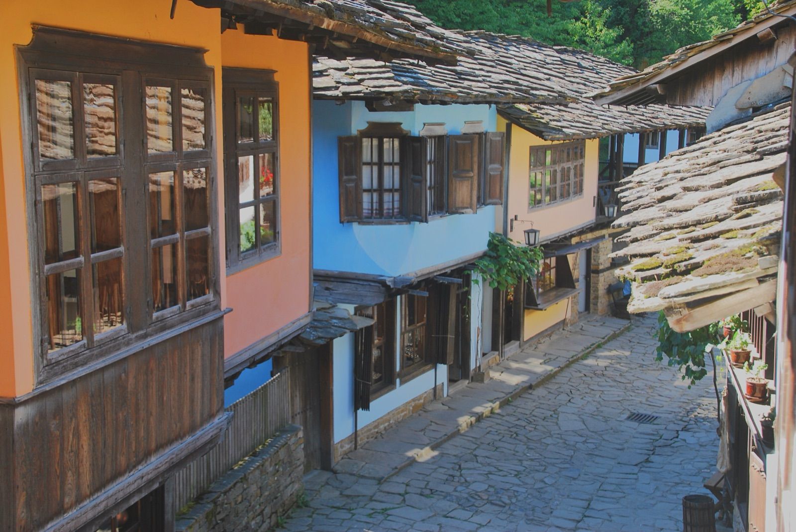 Calle empedrada del complejo etnográfico de Etar con casas de madera y cal y tejados de laja