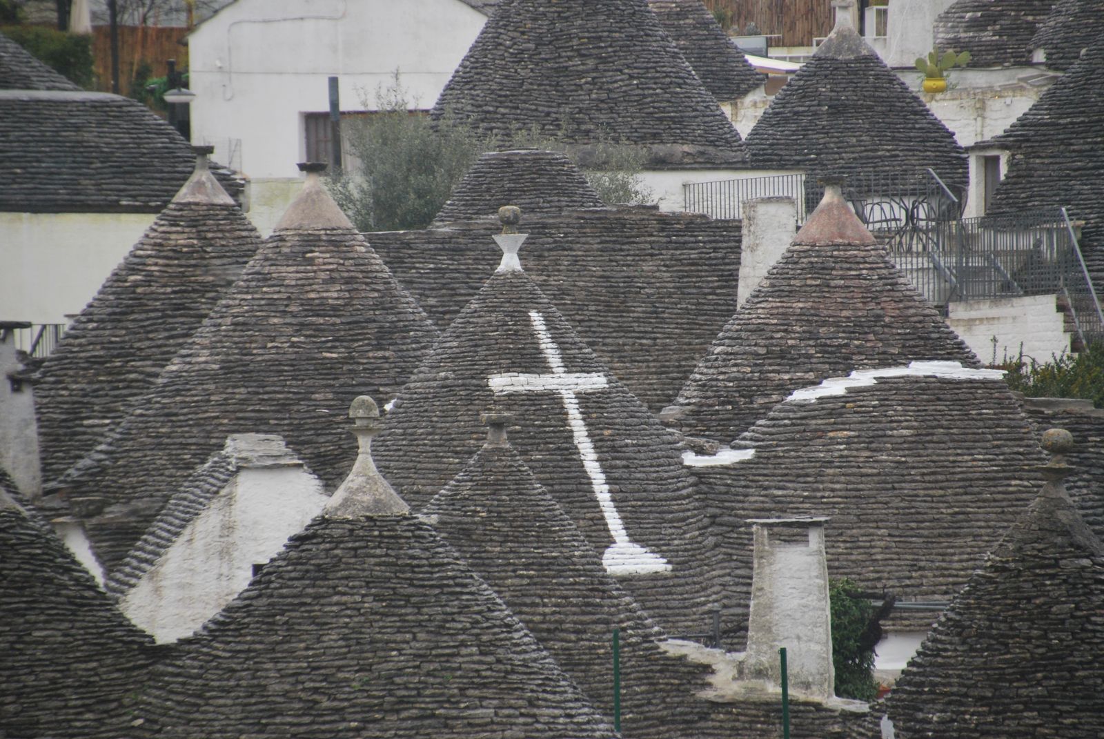 Tejados cónicos de piedra de los trulli de Alberobello con símbolos pintados en blanco