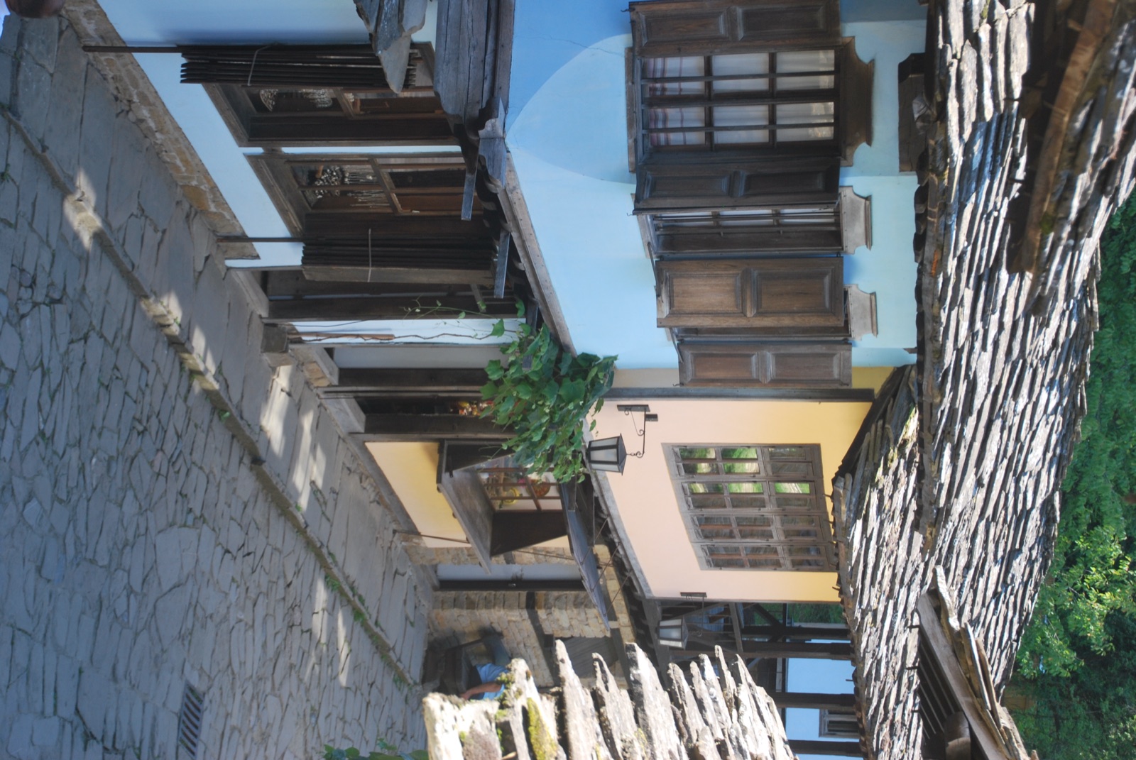 Casa azul con ventanas de madera y farol en un callejón empedrado del museo al aire libre de Etar