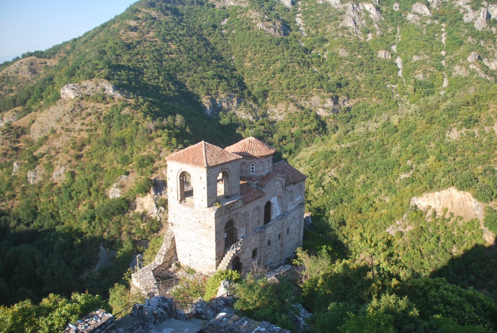 Iglesia medieval de la fortaleza de Asen sobre un espolón rocoso, rodeada de laderas boscosas de los Ródopes