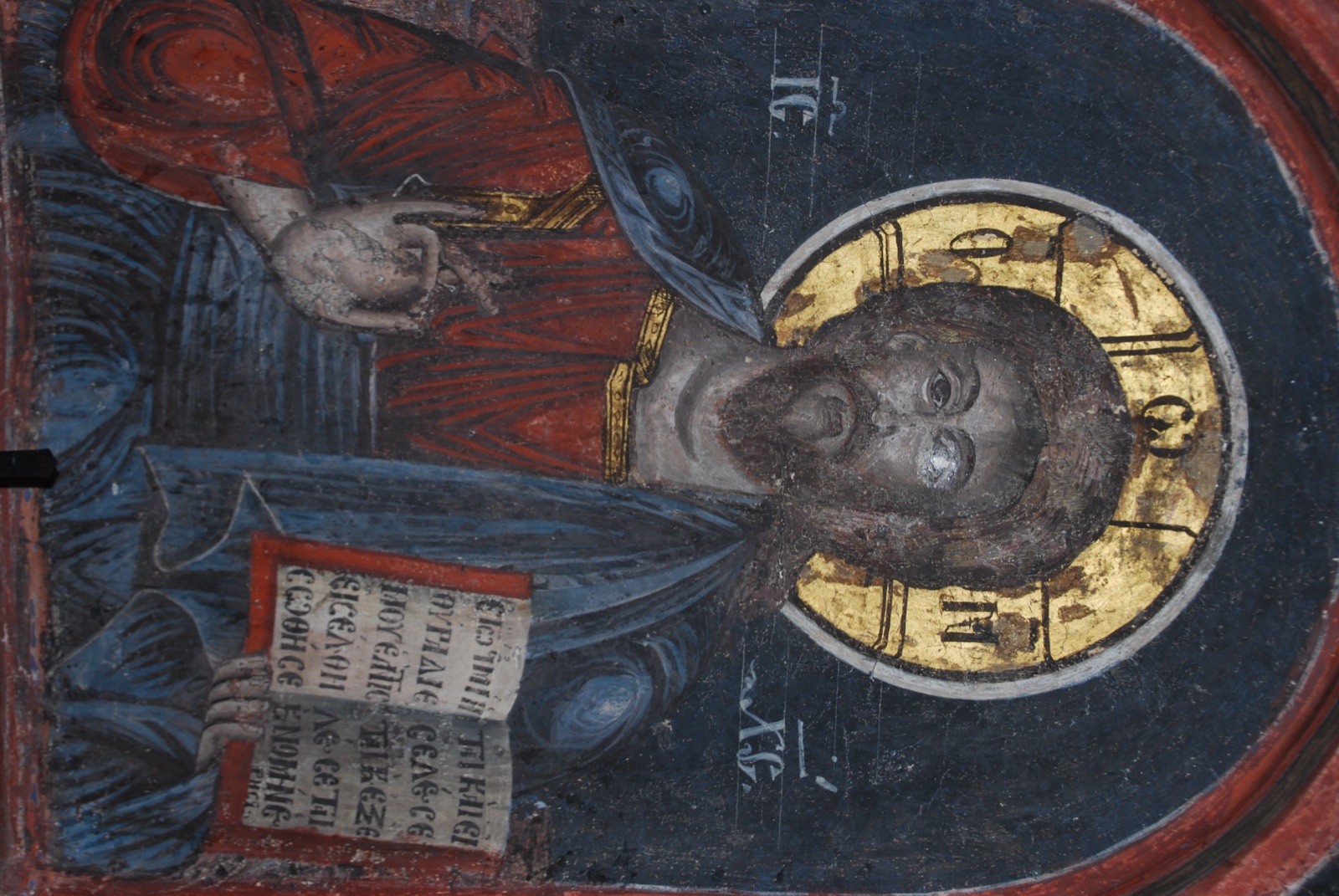 Icono mural de Cristo Pantocrátor con nimbo dorado y libro abierto con texto en cirílico