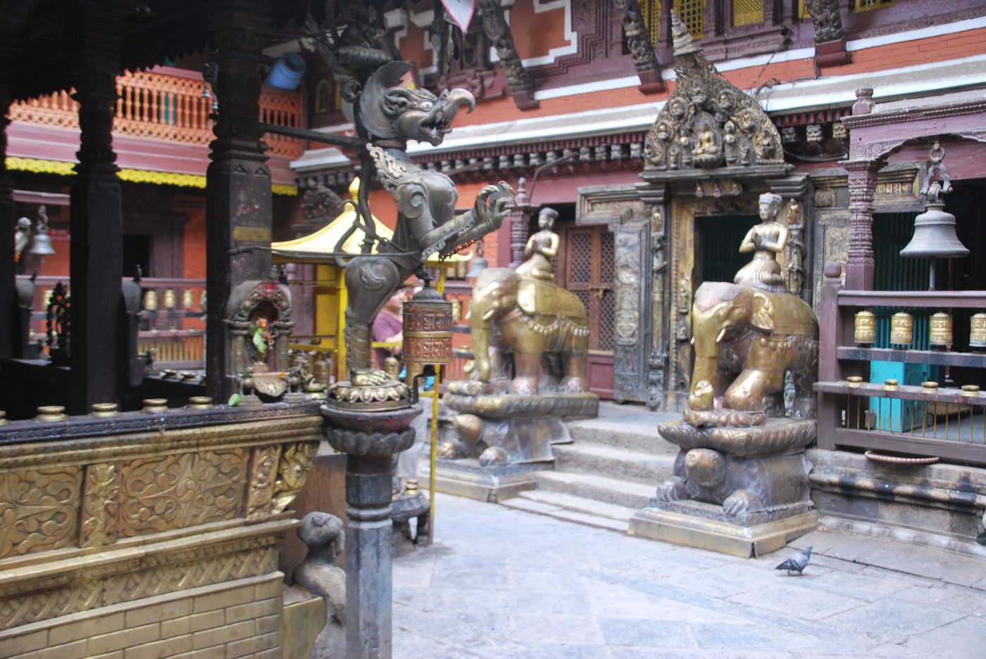 Estatuas y campanas a la entrada de un templo de Katmandú