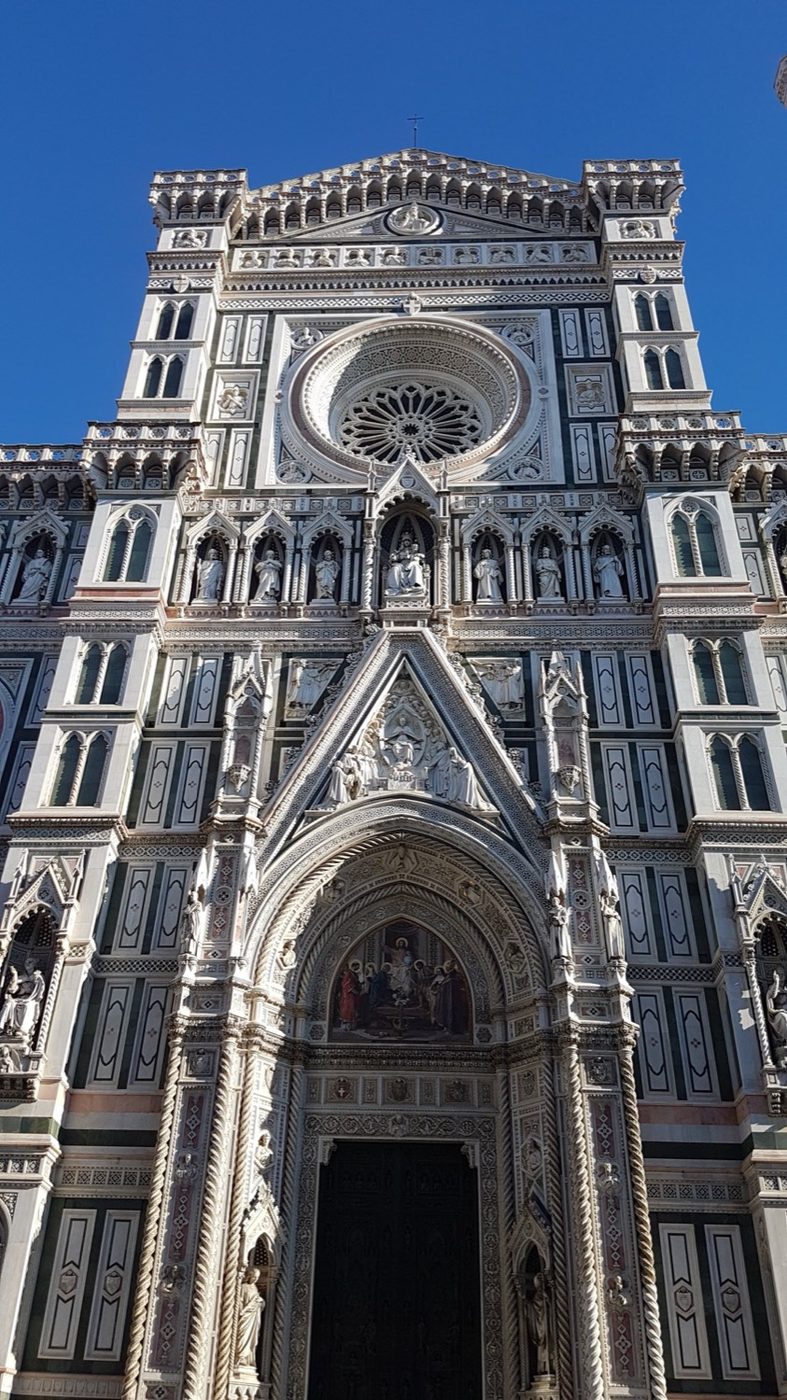 Fachada de mármol policromado del Duomo de Florencia bajo cielo azul