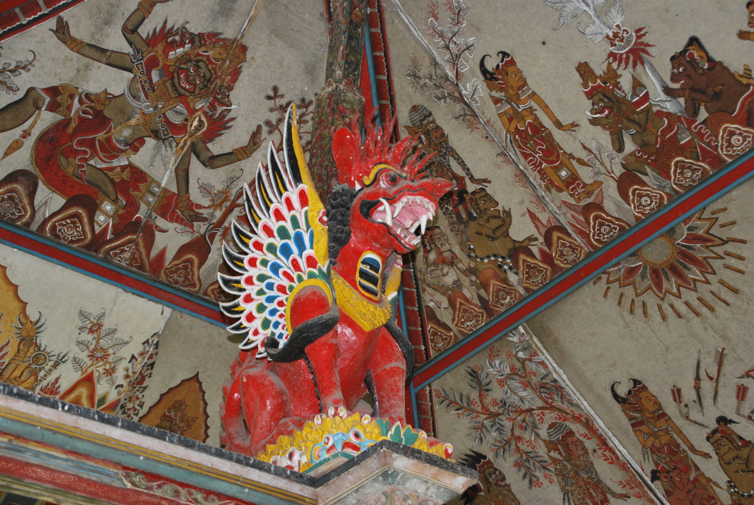 Escultura de Barong, espíritu protector balinés, pintada en rojo y colores en un templo