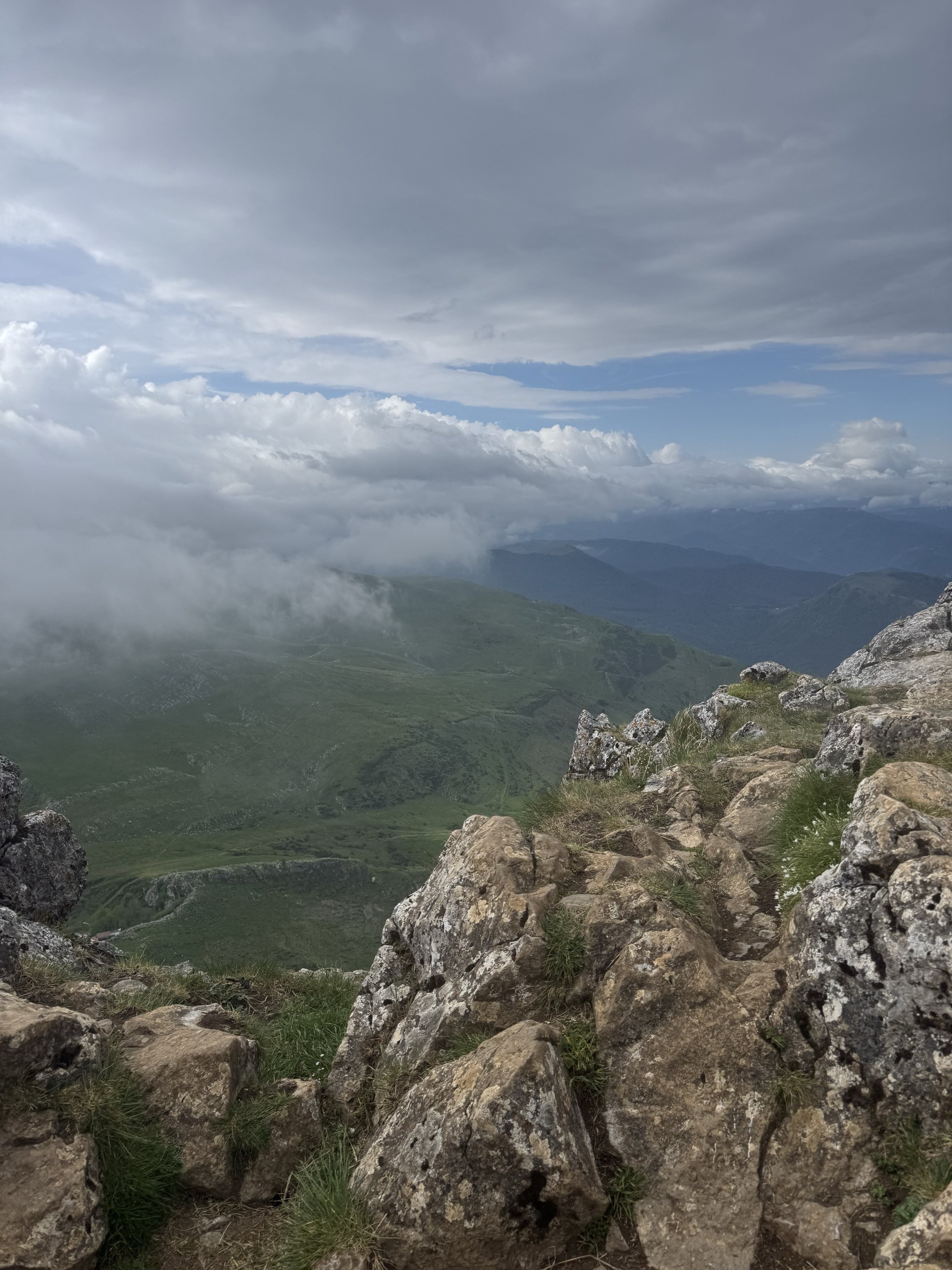 Cara este del Txindoki con paredes calizas verticales y valle profundo con nubes bajas