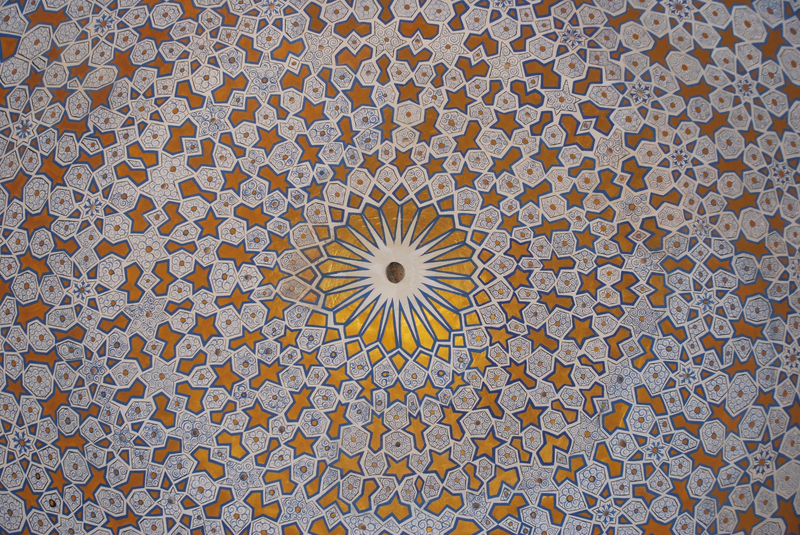 Mosaico geométrico naranja y blanco bajo cúpula timúrida en Samarkanda