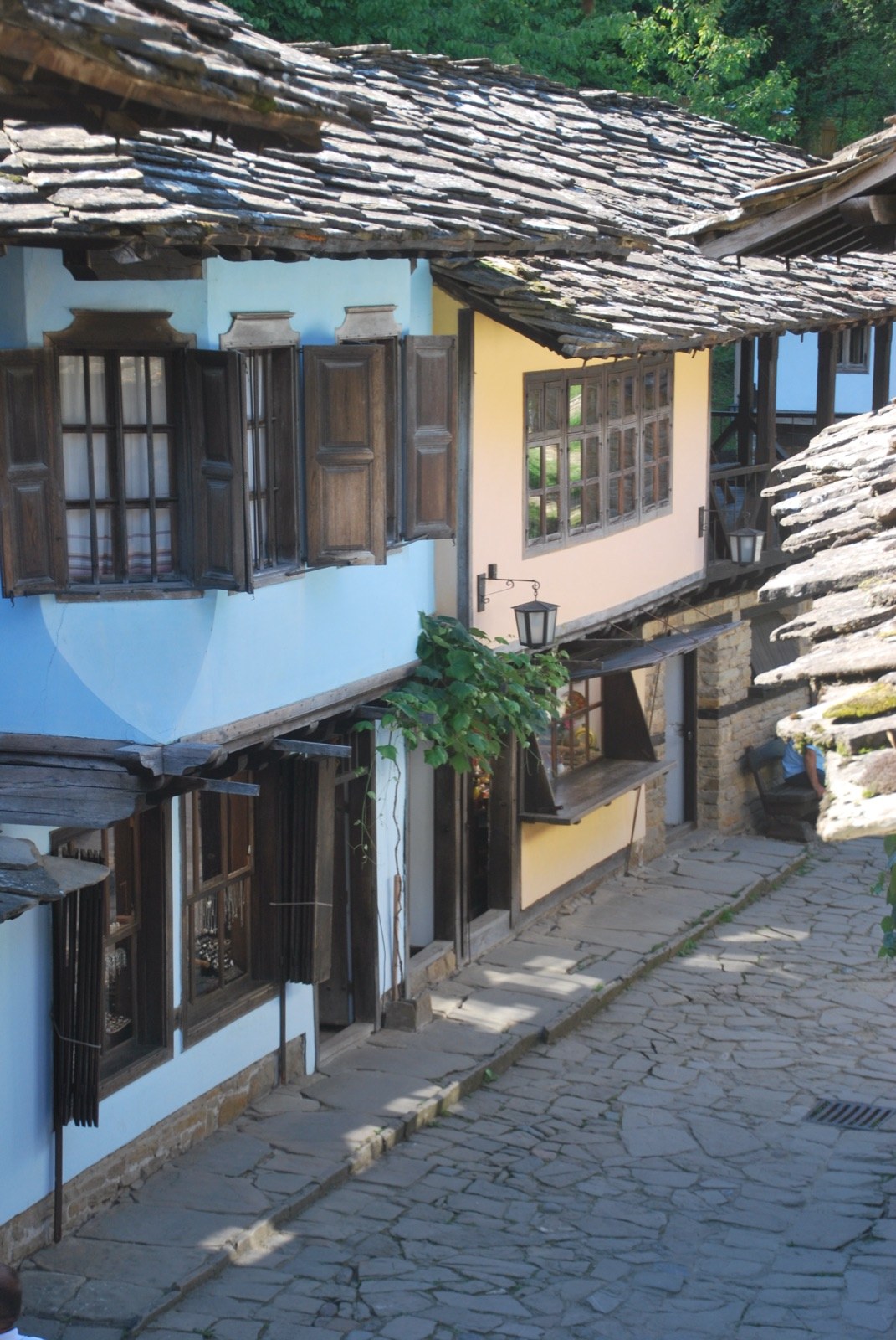 Casa azul con ventanas de madera y farol en un callejón empedrado del museo al aire libre de Etar