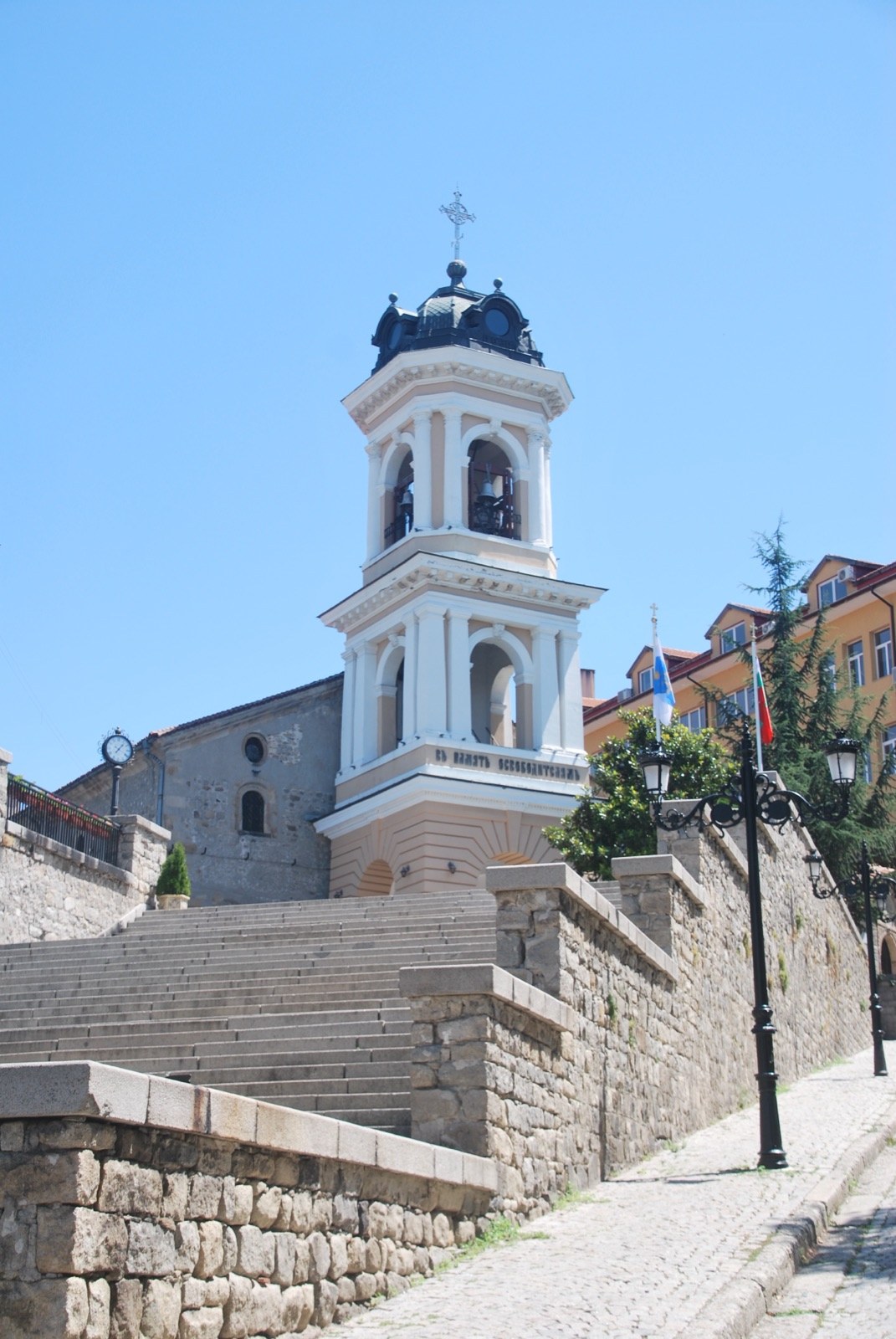 Campanario blanco de la iglesia de la Virgen María sobre la escalinata de piedra que sube al casco viejo de Plovdiv