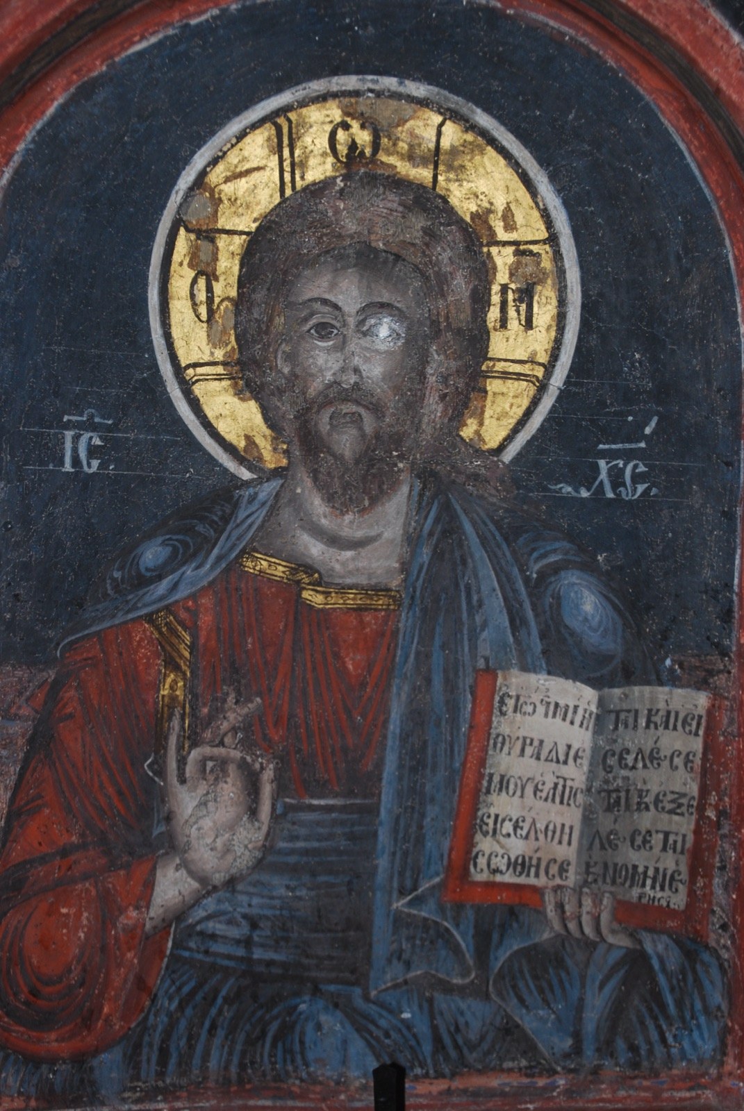Icono mural de Cristo Pantocrátor con nimbo dorado y libro abierto con texto en cirílico