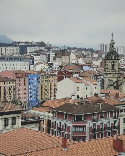 Tejados y fachadas de colores con una torre de iglesia
